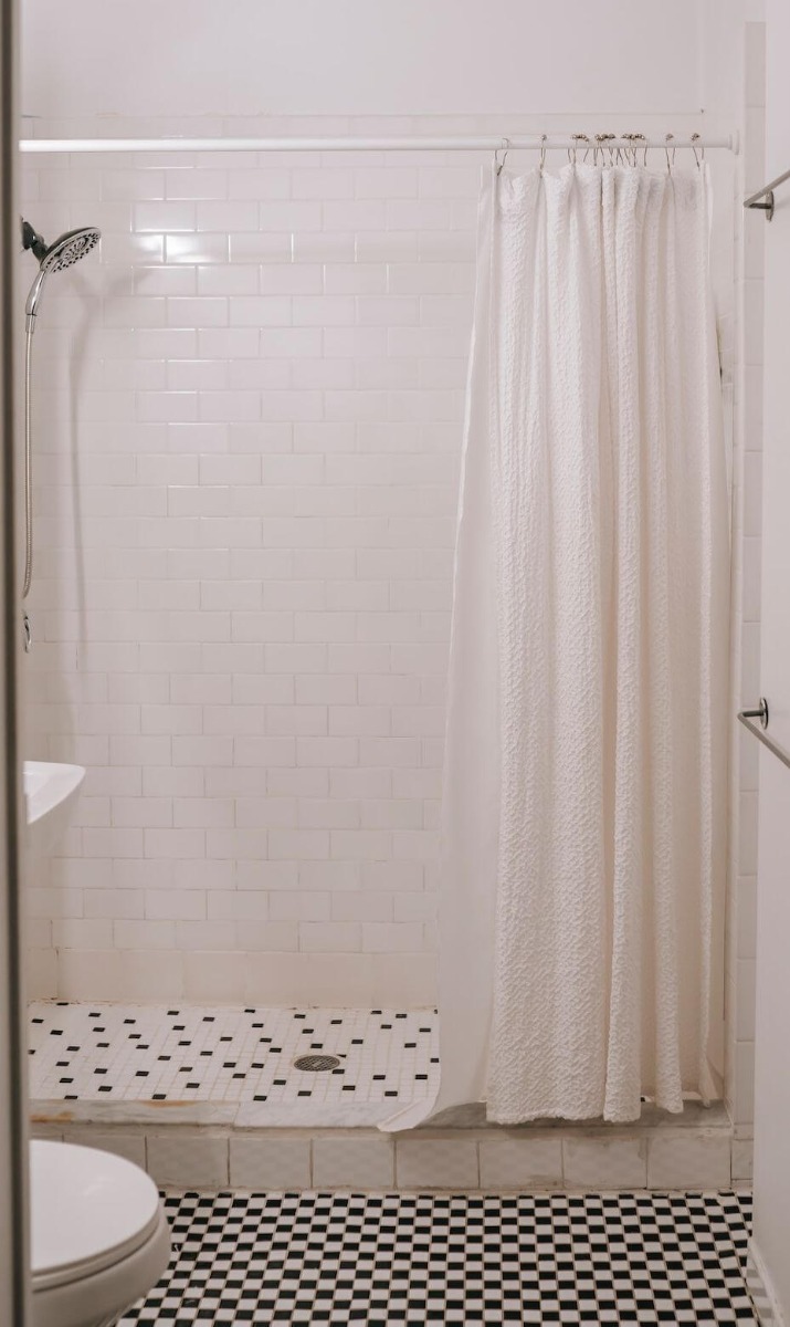 Tuš kabina u malom kupatilu sa tuš zavesom