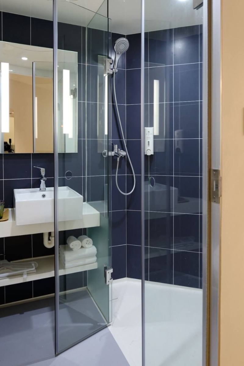 Tuš kabina u kupatilu sa teget pločicama